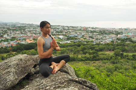 Young woman doing yoga exercises in the garden parkの写真素材