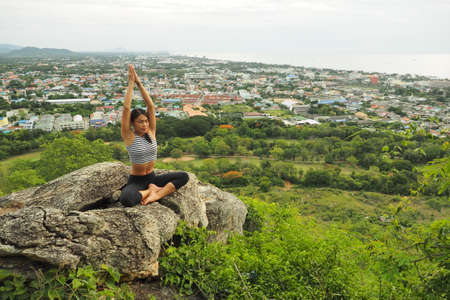 Young woman doing yoga exercises in the garden parkの写真素材