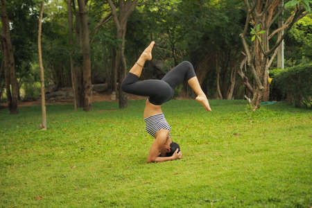 Young woman doing yoga exercises in the garden parkの写真素材