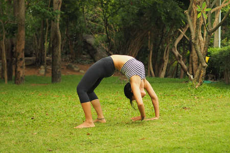 Young woman doing yoga exercises in the garden parkの写真素材