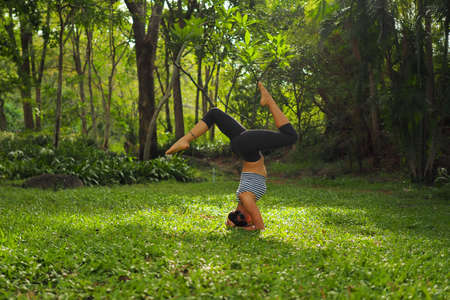 Young woman doing yoga exercises in the garden parkの写真素材