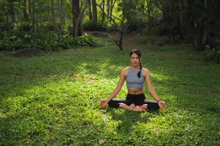 Young woman doing yoga exercises in the garden park