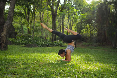 Young woman doing yoga exercises in the garden parkの写真素材
