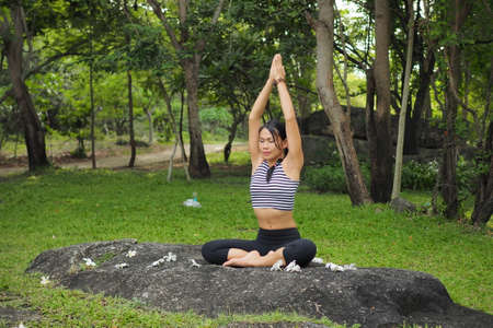 Young woman doing yoga exercises in the garden parkの写真素材
