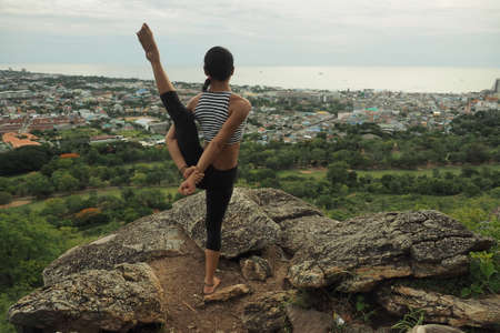 Young woman doing yoga exercises in the garden parkの写真素材