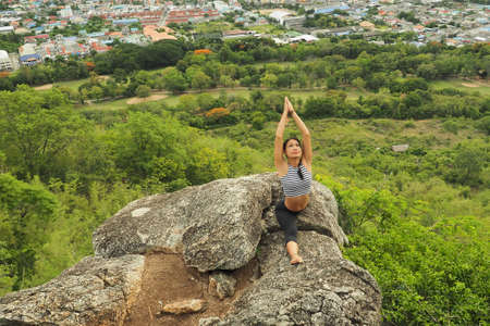 Young woman doing yoga exercises in the garden parkの写真素材