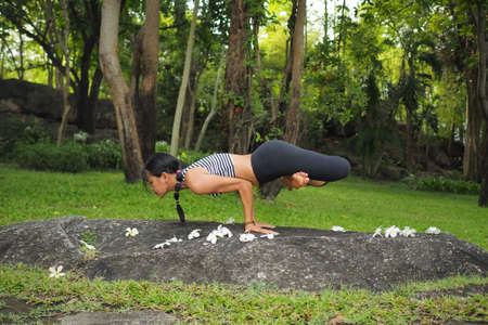 Young woman doing yoga exercises in the garden parkの写真素材