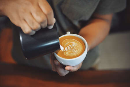 cup of coffee latte on the wood texture   in vintage color toneの写真素材