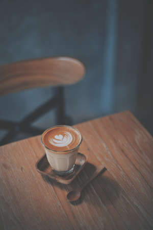 cup of coffee latte on the wood texture   in vintage color toneの写真素材