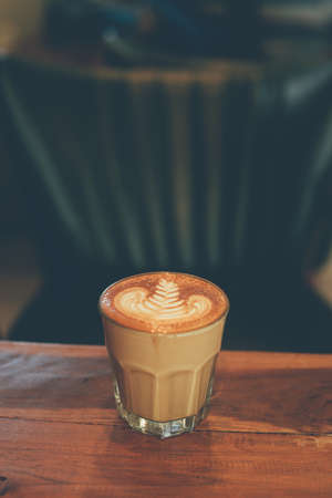 cup of coffee latte on the wood texture   in vintage color toneの写真素材