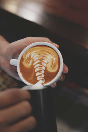 cup of coffee latte on the wood texture   in vintage color toneの写真素材