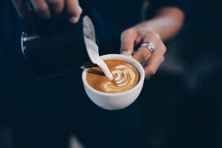 cup of coffee latte on the wood texture   in vintage color toneの写真素材