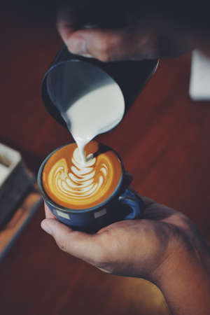 cup of coffee latte on the wood texture   in vintage color toneの写真素材