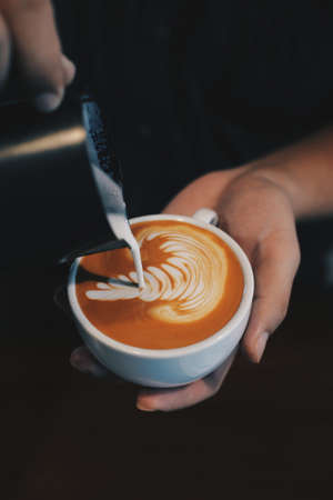 cup of coffee latte on the wood texture   in vintage color toneの写真素材