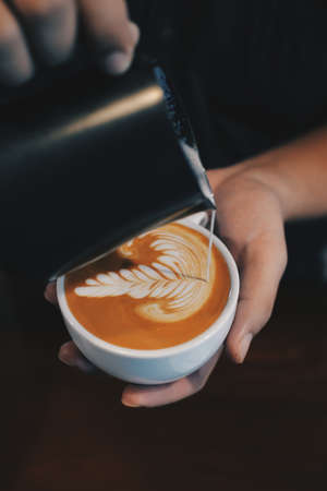 cup of coffee latte on the wood texture   in vintage color toneの写真素材