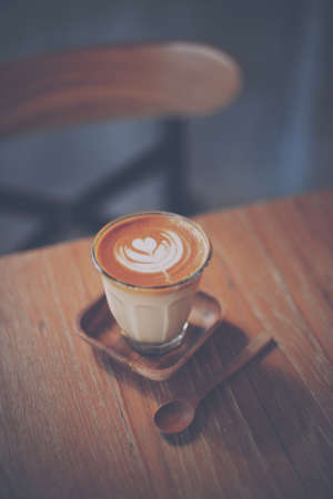 cup of coffee latte on the wood texture   in vintage color toneの写真素材