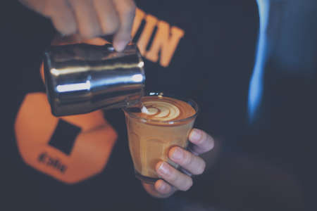 cup of coffee latte on the wood texture   in vintage color toneの写真素材