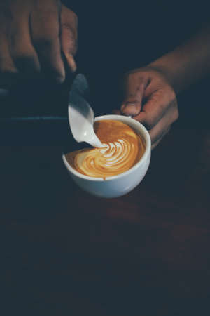 cup of coffee latte on the wood texture   in vintage color toneの写真素材