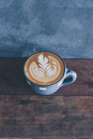 cup of coffee latte on the wood texture   in vintage color toneの写真素材