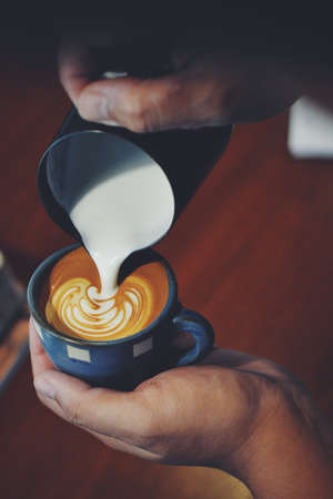 cup of coffee latte on the wood texture   in vintage color toneの写真素材