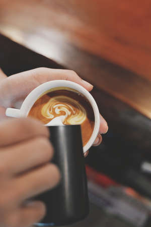 cup of coffee latte on the wood texture   in vintage color toneの写真素材