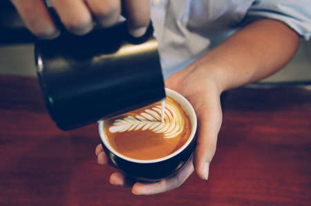 cup of coffee latte on the wood texture   in vintage color toneの写真素材