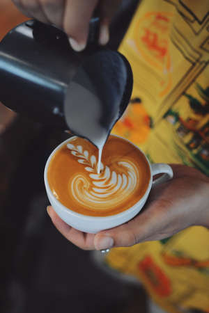 cup of coffee latte on the wood texture   in vintage color toneの写真素材