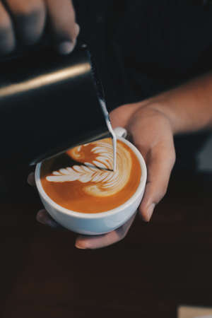 cup of coffee latte on the wood texture   in vintage color toneの写真素材