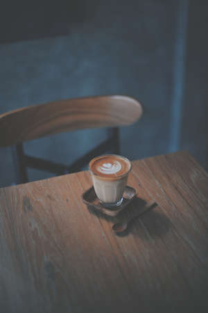cup of coffee latte on the wood texture   in vintage color toneの写真素材