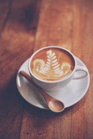 cup of coffee latte on the wood texture   in vintage color toneの写真素材