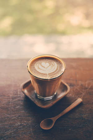 cup of coffee latte on the wood texture   in vintage color toneの写真素材