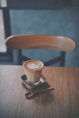 cup of coffee latte on the wood texture   in vintage color toneの写真素材