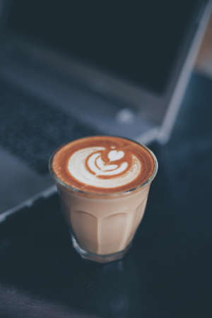 cup of coffee latte on the wood texture   in vintage color toneの写真素材