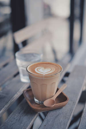 cup of coffee latte on the wood texture   in vintage color toneの写真素材