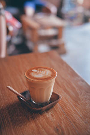 cup of coffee latte on the wood texture   in vintage color toneの写真素材