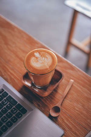 cup of coffee latte on the wood texture   in vintage color toneの写真素材