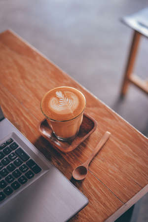cup of coffee latte on the wood texture   in vintage color toneの写真素材