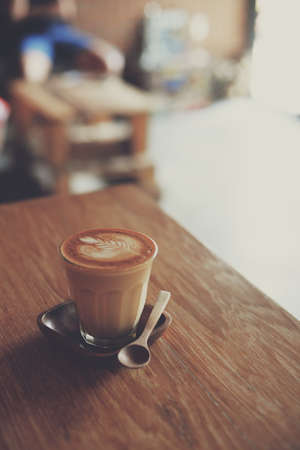 cup of coffee latte on the wood texture   in vintage color toneの写真素材
