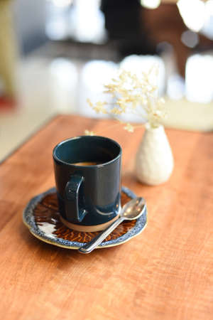 cup of coffee latte art on the wooden desk in coffee shop cafe with vintage color tone filter backgroundの写真素材