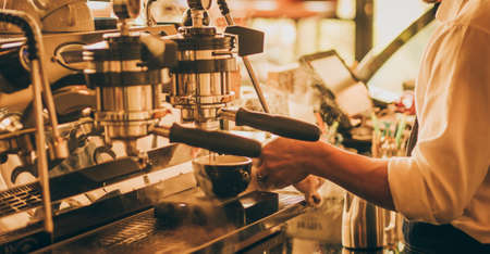 barista make coffee latte art with coffee espresso machine in coffee shop cafe in vintage color toneの写真素材