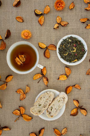 Herbal tea with dried flowers and peaches on sackcloth background.の写真素材
