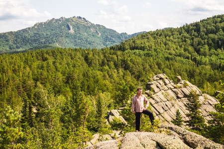 Man standing on top of a mountain. Trees growing from stone. Altai region, Russia.の写真素材