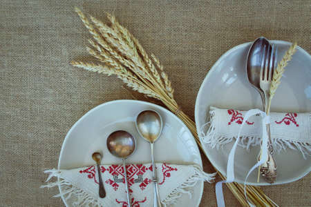 Table setting for two person with dishes and cutlery on napkinの写真素材