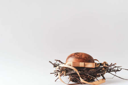 Brown nest with easter egg on a white background.