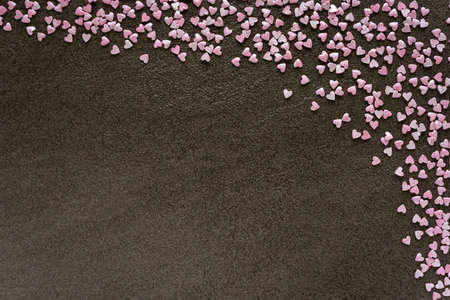 Small love hearts on ceramic brown background.の写真素材