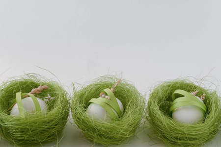Green nests with white eggs on a white background
