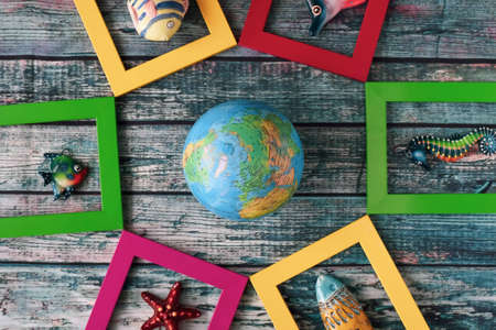 Marine theme - ceramic fish in multi-colored frames and a globe.の写真素材