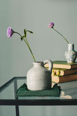 Retro home decor: a stack of books, flower in a vase.の写真素材