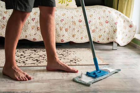 Man husband cleaning the house helping wife.の写真素材