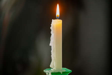 Burning white candle on a dark background.の写真素材